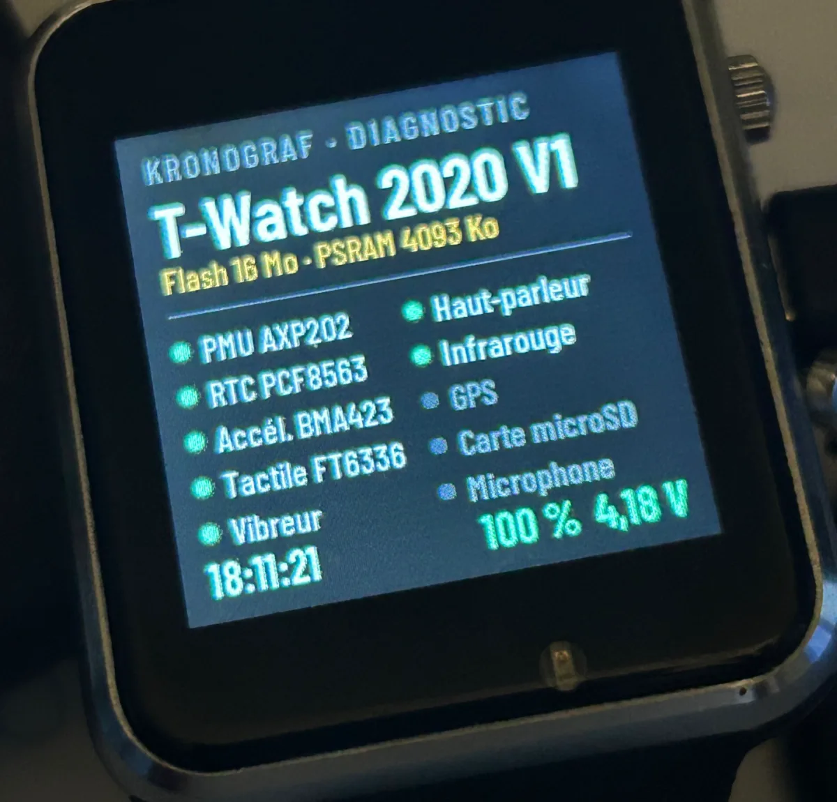 The real T-Watch 2020 lying on the table: Kronograf diagnostic screen, memory, sensors detected in green, battery at 100%